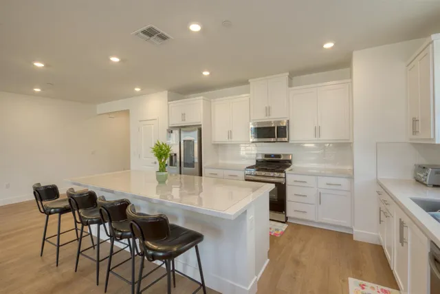 a kitchen with stainless steel appliances granite countertop a stove a sink a refrigerator and a microwave