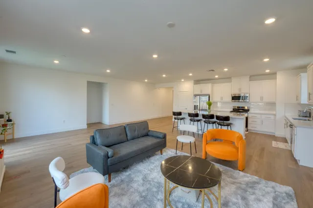 a living room with furniture kitchen and a table