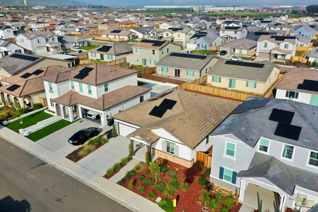an aerial view of a house with a backyard