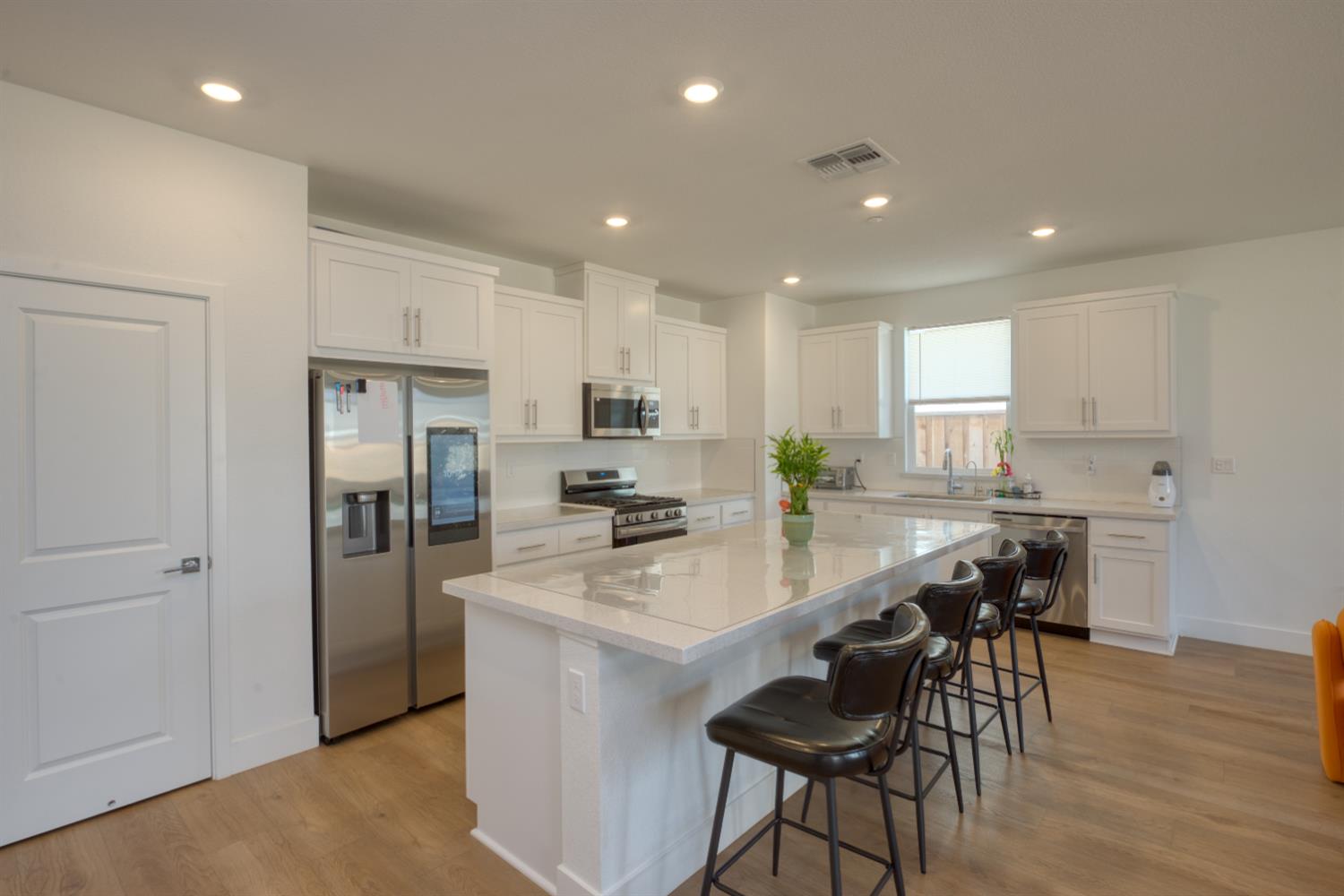 2209 Greenhorn Road Patterson, CA 95363 - Photo 8 of 32 a kitchen with refrigerator a sink and chairs