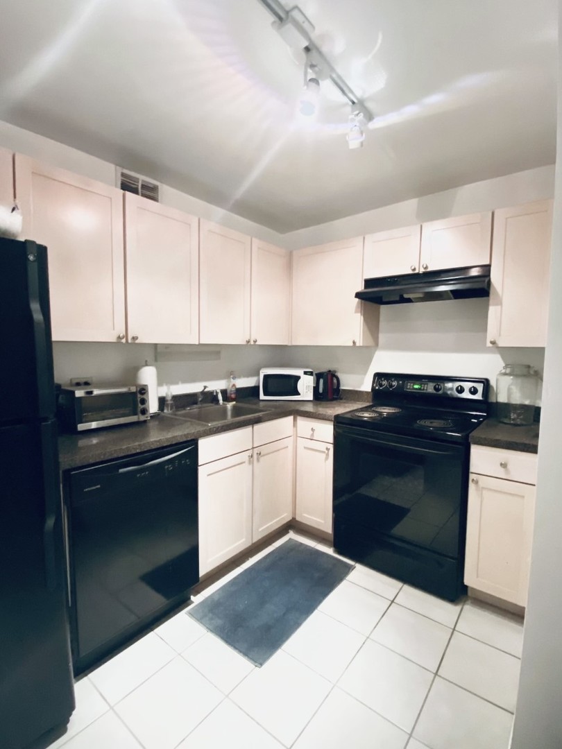 655 West Irving Park Road, Unit 2009 Chicago, IL 60613 - Photo 5 of 7 a kitchen with a stove and a refrigerator