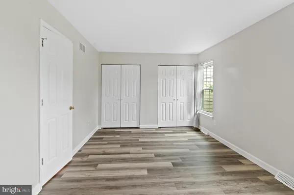 a view of a room with wooden floor and windows