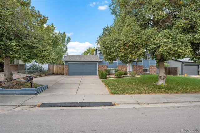 a front view of a house with a yard and a garage