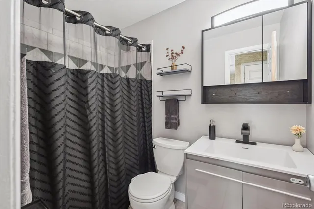 a bathroom with a toilet sink vanity and mirror