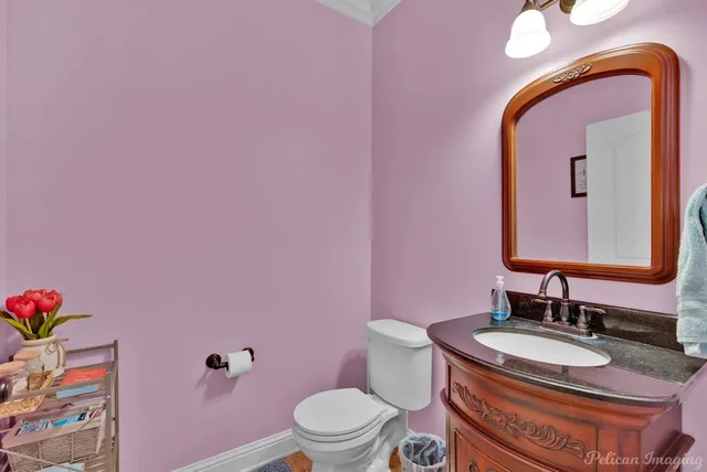 a bathroom with a granite countertop toilet sink and mirror