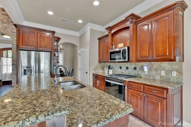 a large kitchen with stainless steel appliances granite countertop a stove and a refrigerator