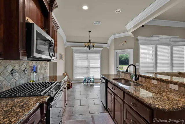 a kitchen with stainless steel appliances granite countertop a sink stove and refrigerator