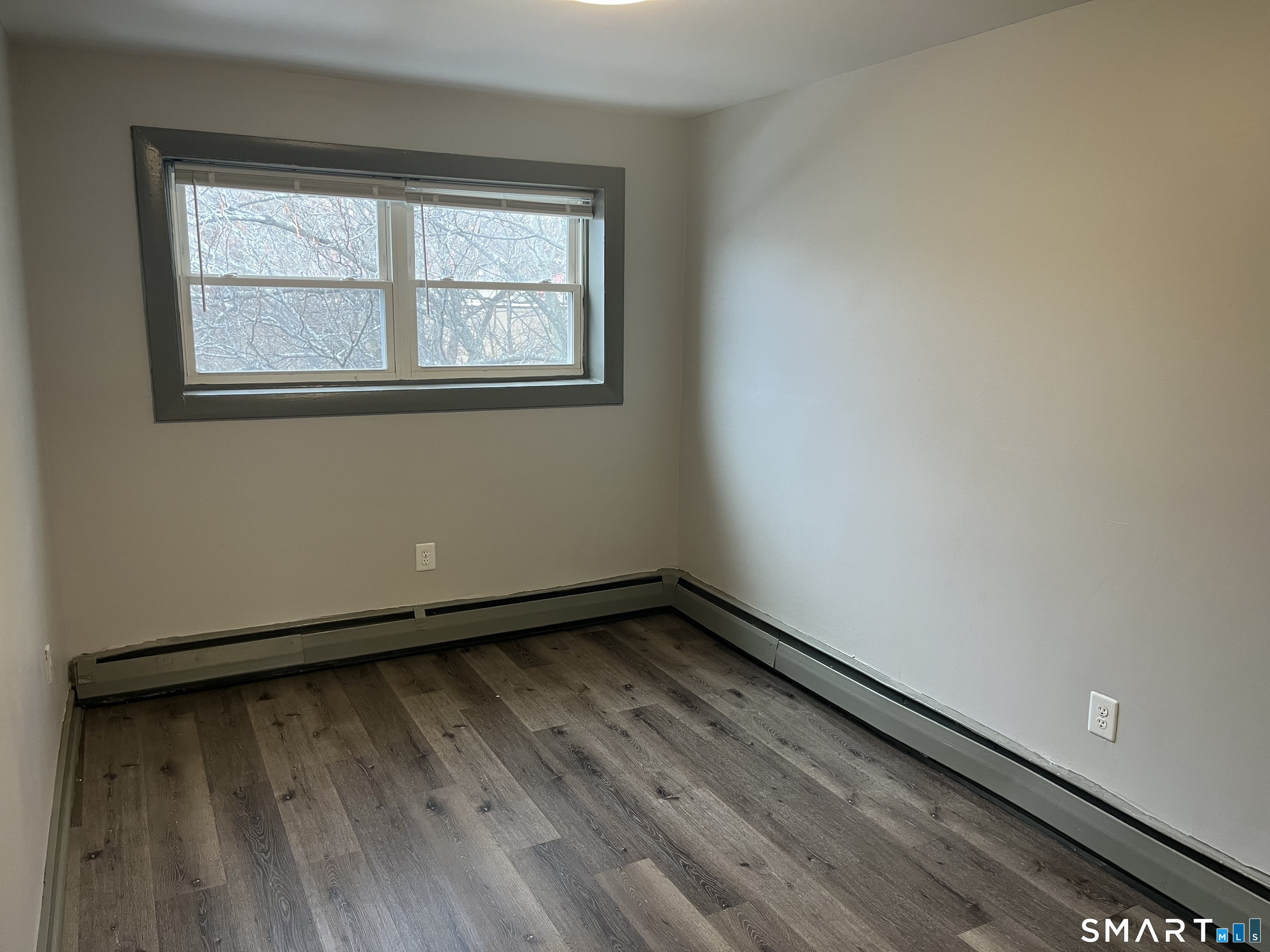 32 Cook Avenue, Unit 305 Meriden, CT 06451 - Photo 11 of 16 a view of an empty room with wooden floor and a window