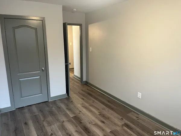 an empty room with wooden floor and closet