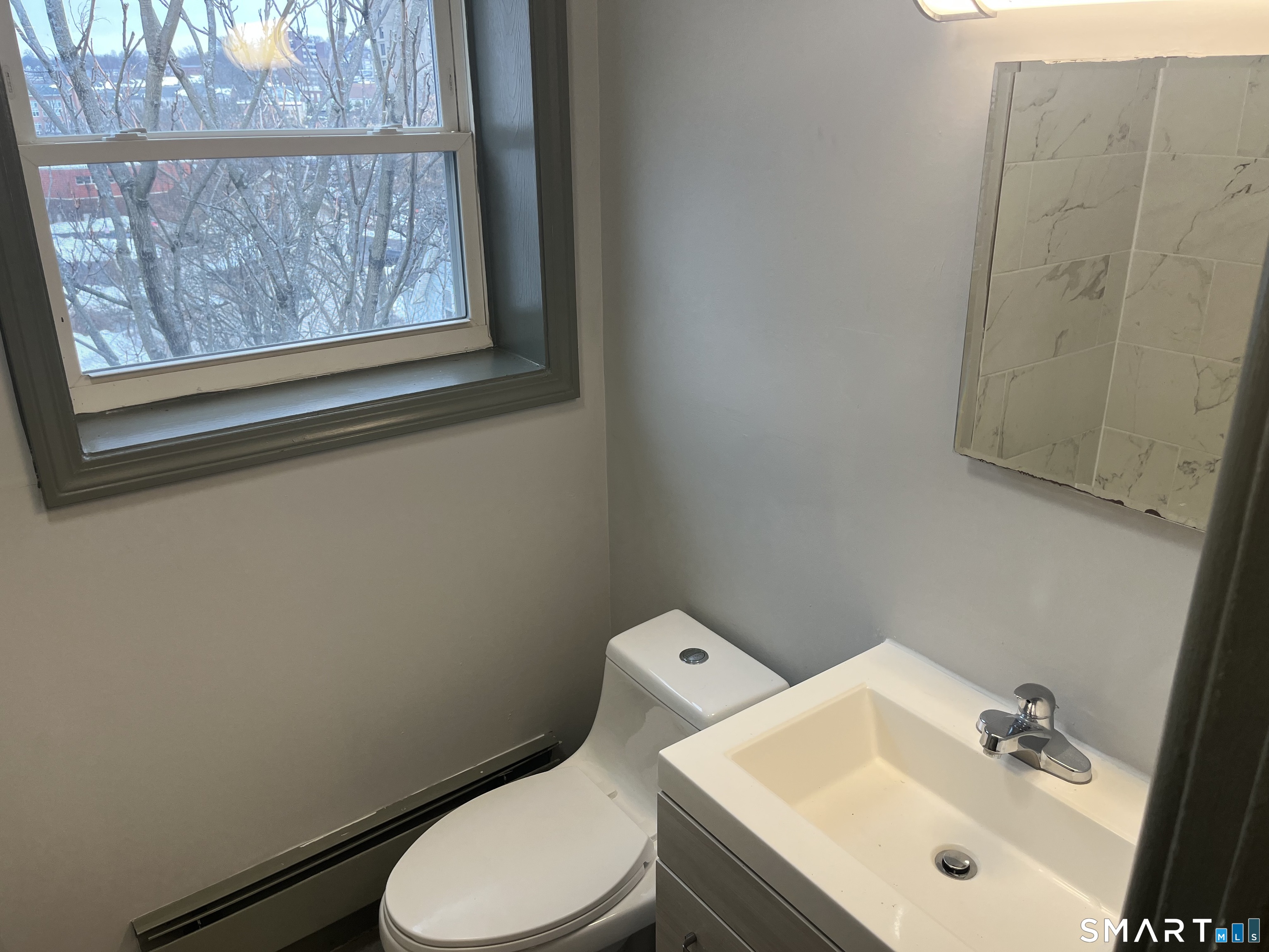 32 Cook Avenue, Unit 305 Meriden, CT 06451 - Photo 13 of 16 a bathroom with a sink mirror and toilet