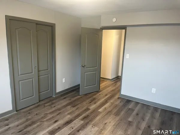 an empty room with wooden floor and door