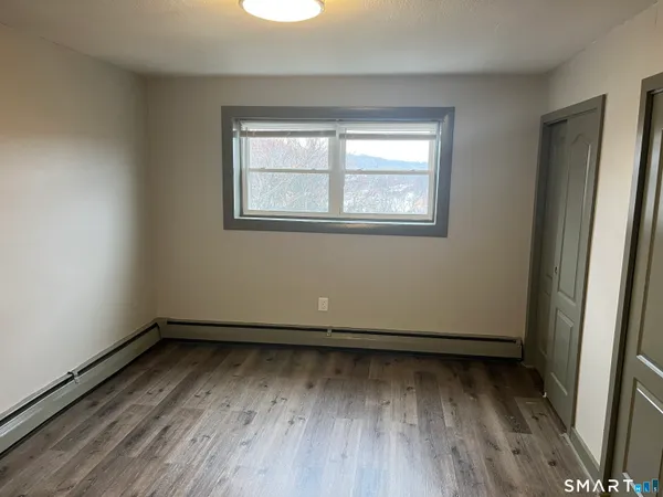a view of a room with wooden floor and window