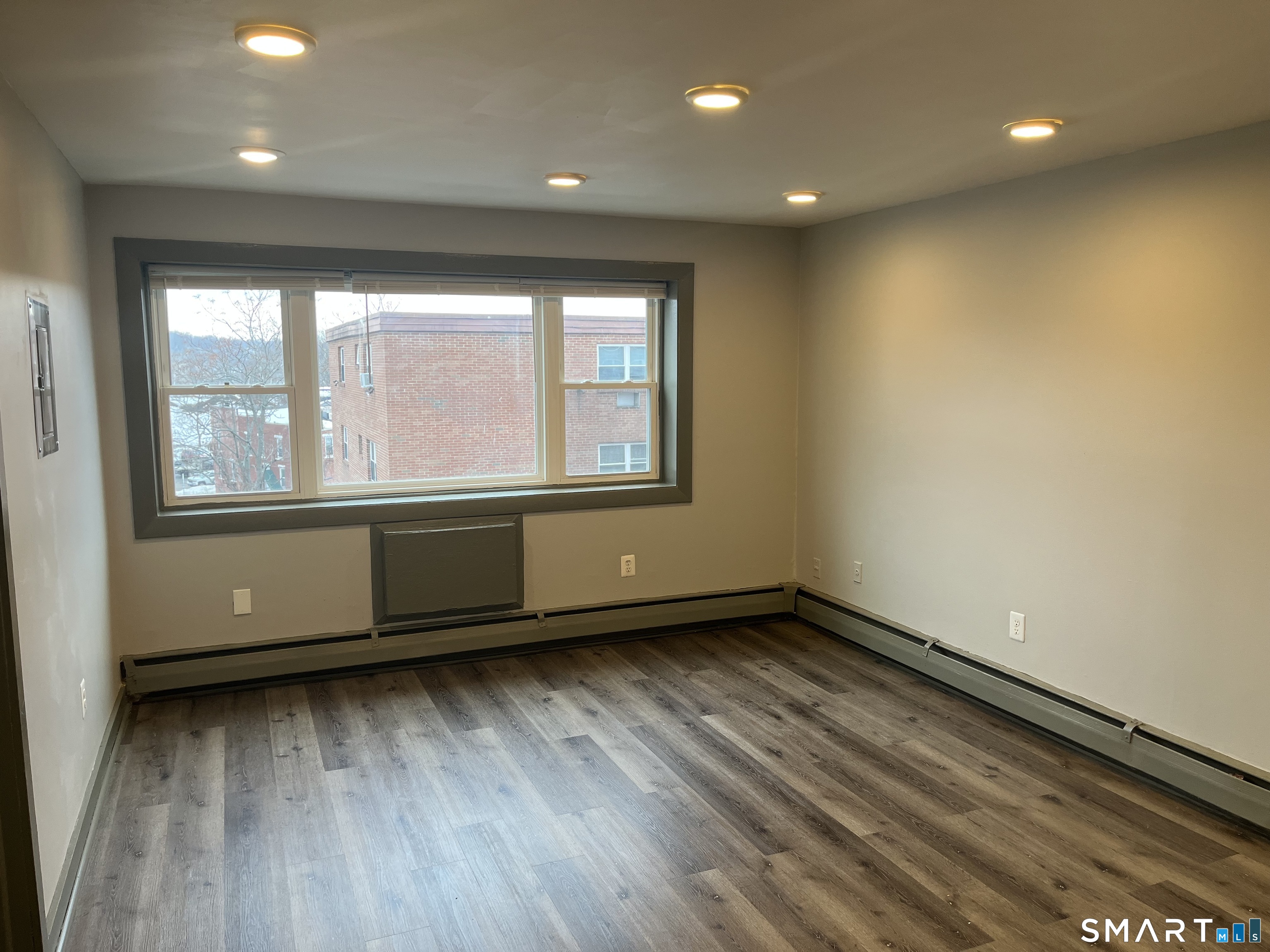 32 Cook Avenue, Unit 305 Meriden, CT 06451 - Photo 7 of 16 an empty room with wooden floor and windows