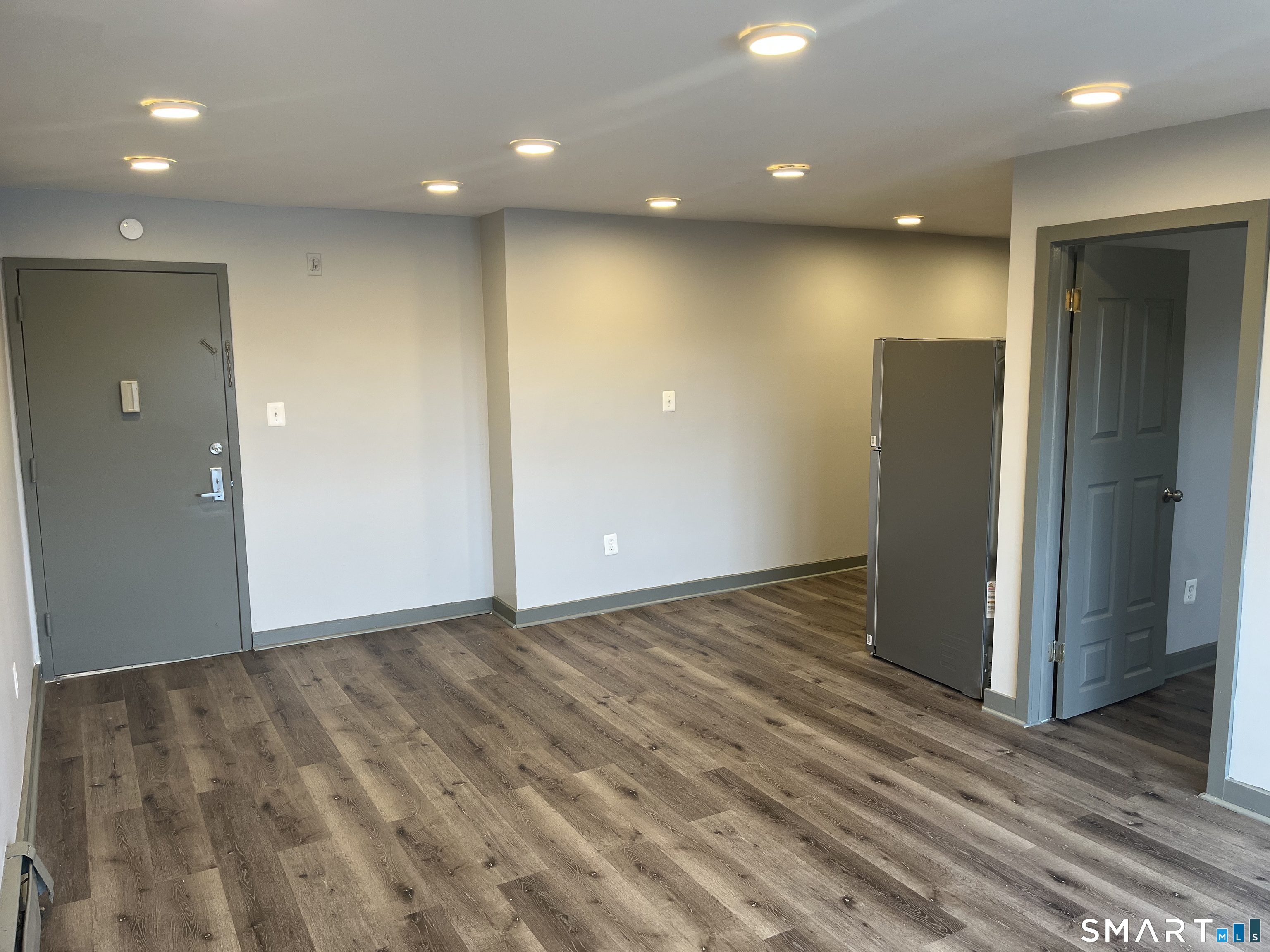 32 Cook Avenue, Unit 305 Meriden, CT 06451 - Photo 8 of 16 an empty room with wooden floor and entrance