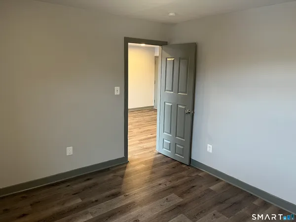 an empty room with wooden floor and closet