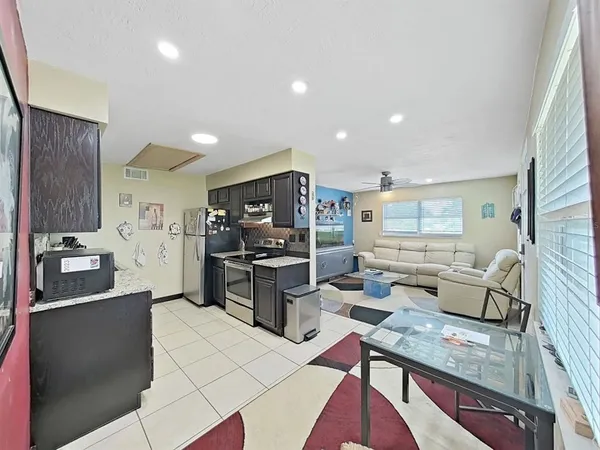a kitchen with stainless steel appliances kitchen island granite countertop a refrigerator and a stove top oven