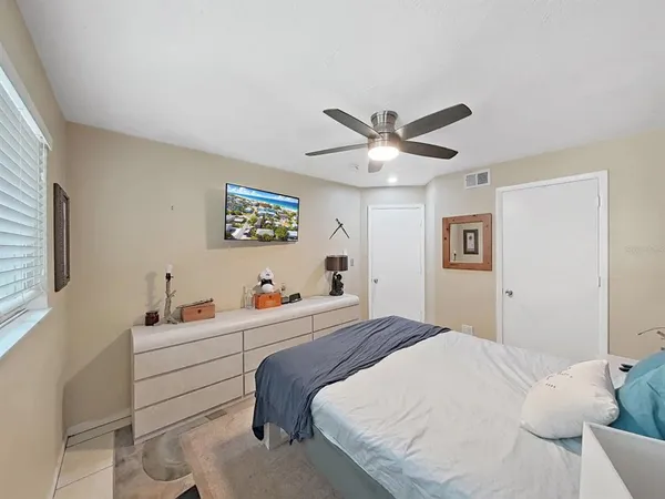 a bedroom with a bed a window and a dresser