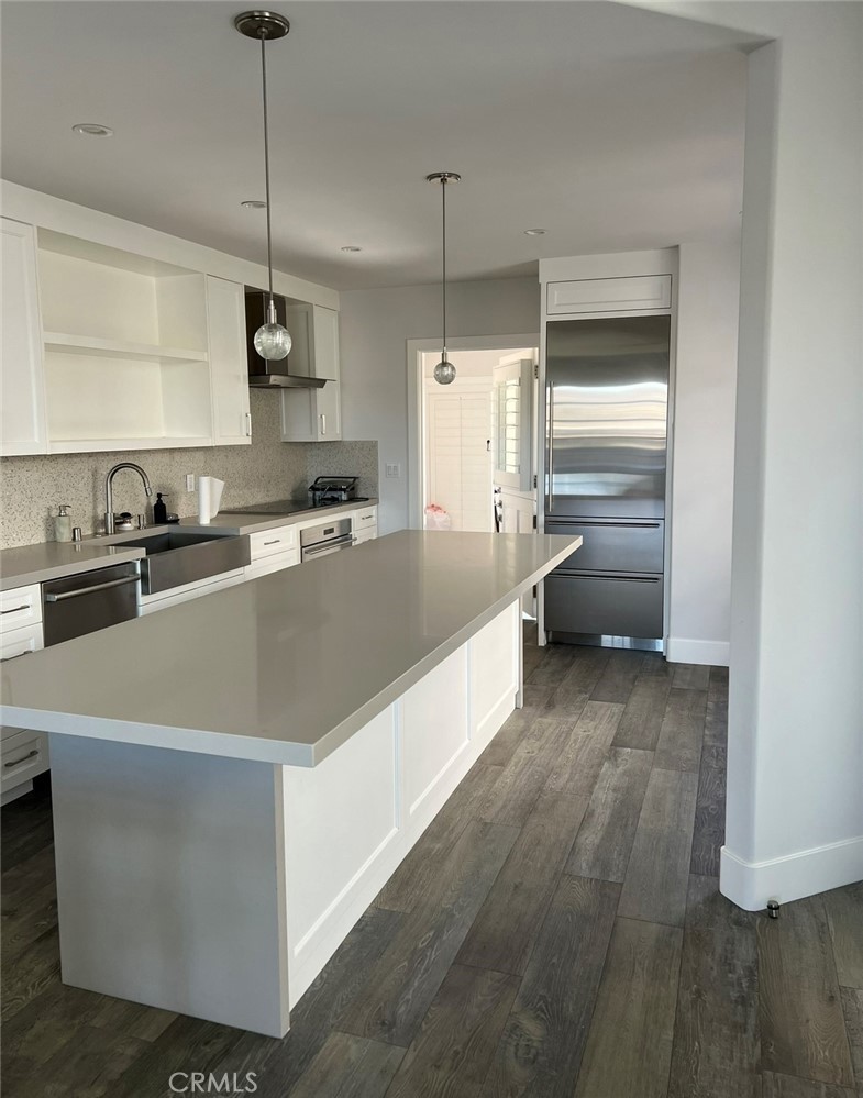2929 Sandy Pointe, Unit 19 Del Mar, CA 92014 - Photo 4 of 17 a large kitchen with kitchen island a stove a sink a center island and wooden floor