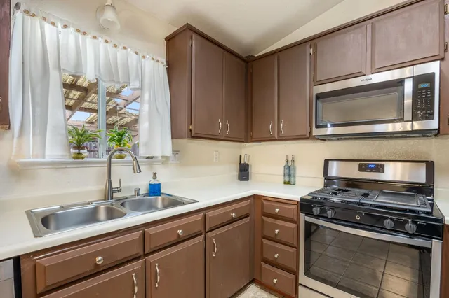 a kitchen with stainless steel appliances wooden cabinets and a stove top oven