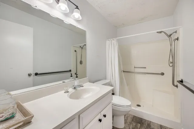 a bathroom with a sink a toilet and shower