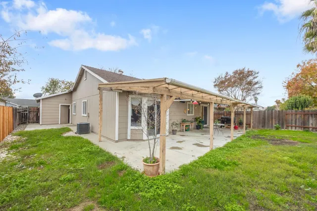 a front view of house with yard and glass top table and chairs