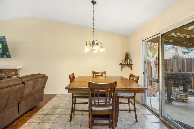 a view of a dining room with furniture and a chandelier