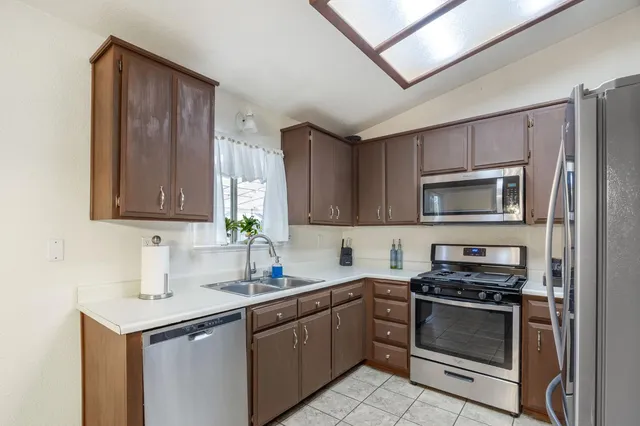 a kitchen with stainless steel appliances a stove a sink and a microwave