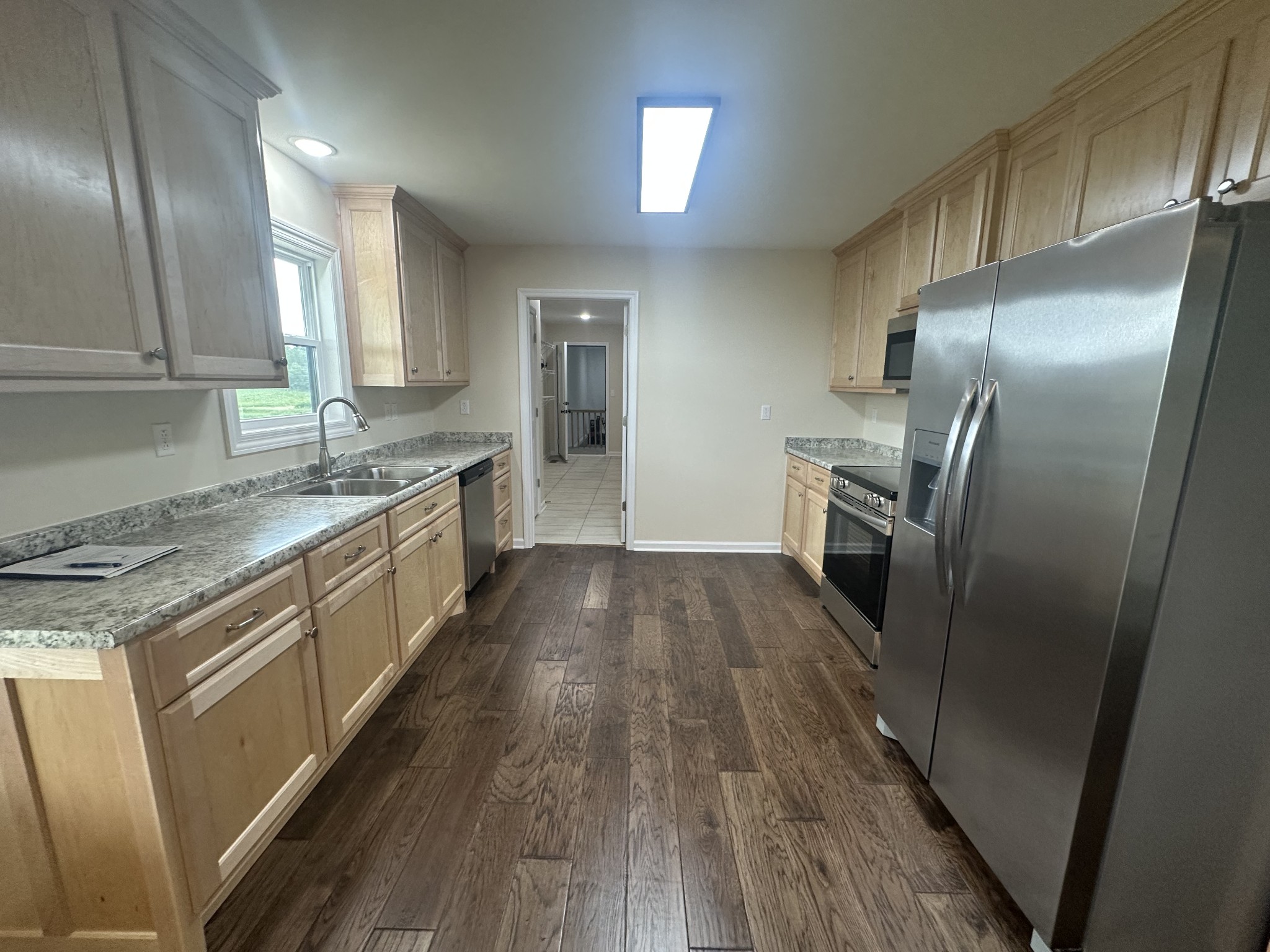 1654 Linville Road Lawrenceburg, TN 38464 - Photo 20 of 33 a kitchen with granite countertop a refrigerator a sink a stove and cabinets