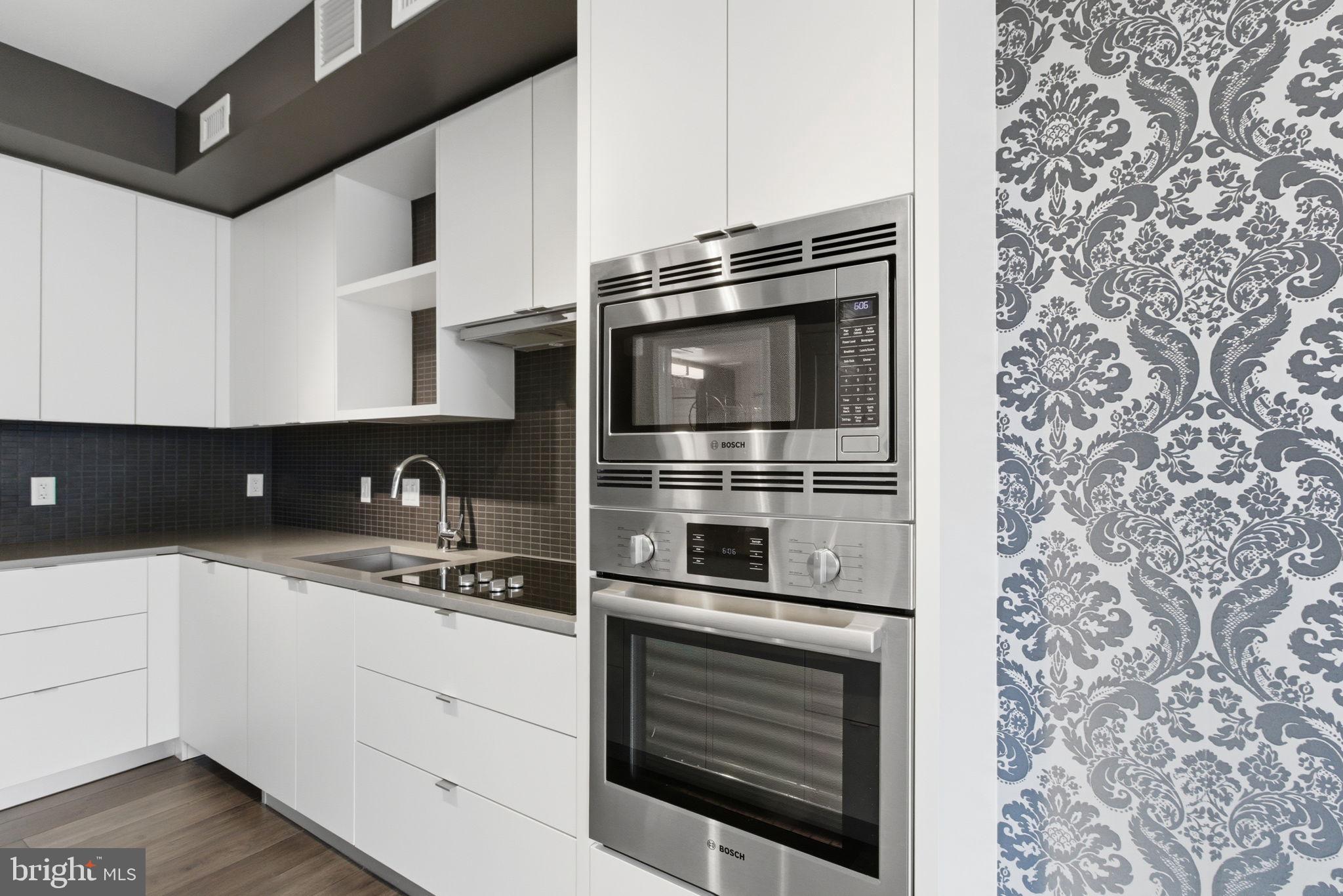 1300 4th Street Southeast, Unit 713 Washington, DC 20003 - Photo 2 of 29 a kitchen with stainless steel appliances a stove a microwave and cabinets