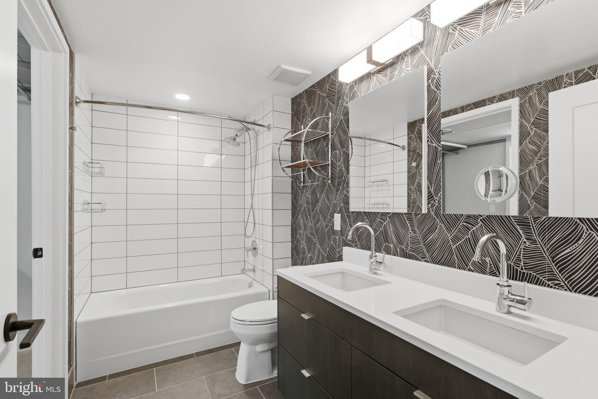 1300 4th Street Southeast, Unit 713 Washington, DC 20003 - Photo 8 of 29 a bathroom with a bathtub shower sink vanity mirror and toilet