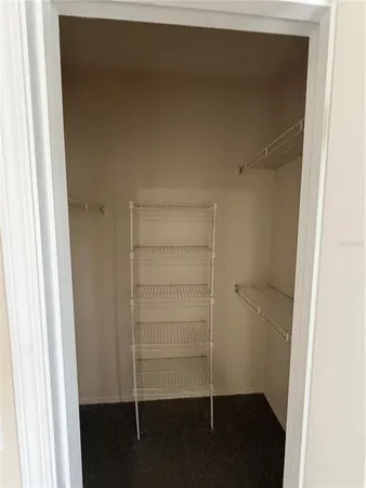 a view of a hallway with wooden floor and a livingroom