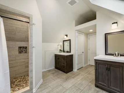 a spacious bathroom with a sink a mirror and a shower