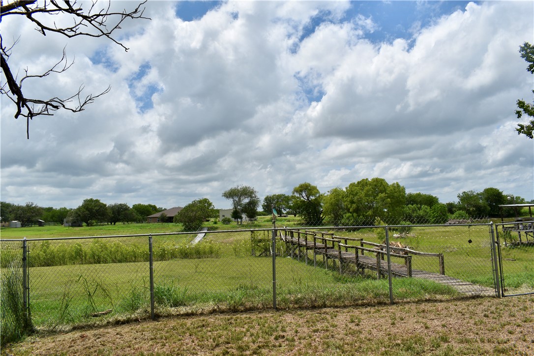 25051 Lake Shore Drive Mathis, TX 78368 - Photo 3 of 40 a view of a green field with wooden fence