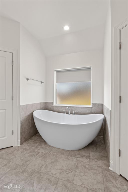 304 Prien Lk Loop Bossier City, LA 71111 - Photo 27 of 39 Freestanding soaking tub with chrome fixtures, set against a tiled wainscoting