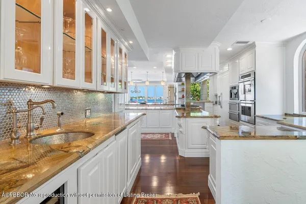 a view of a kitchen with kitchen island granite countertop a large window and a sink