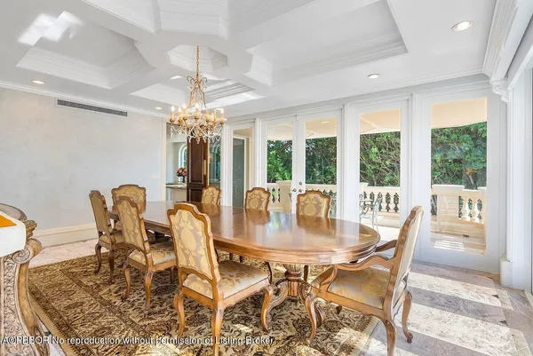 a dining room with furniture a chandelier and large windows