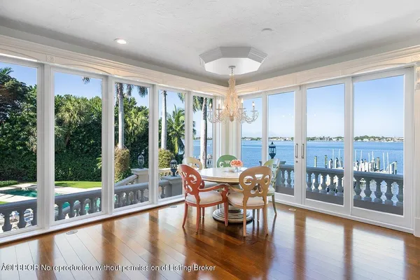 a dining room with furniture water view and large windows