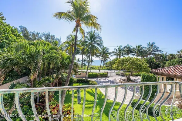 a view of swimming pool with outdoor seating and trees in the background