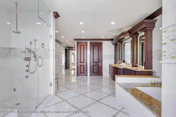 a bathroom with glass door shower a sink and a mirror