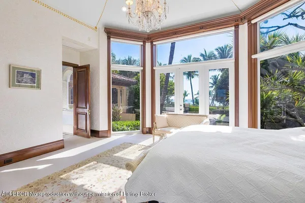 a large bedroom with a large window and a chandelier