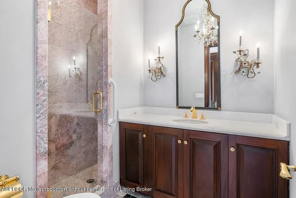 a bathroom with a granite countertop shower a sink and a mirror