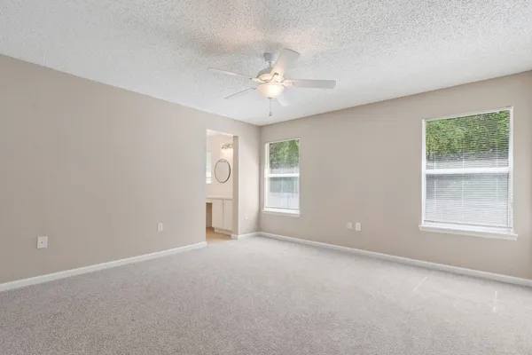 an empty room with a window and a ceiling fan