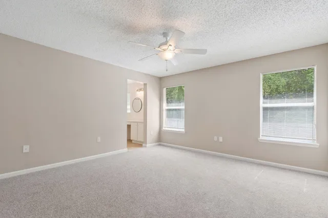 an empty room with a window and a ceiling fan