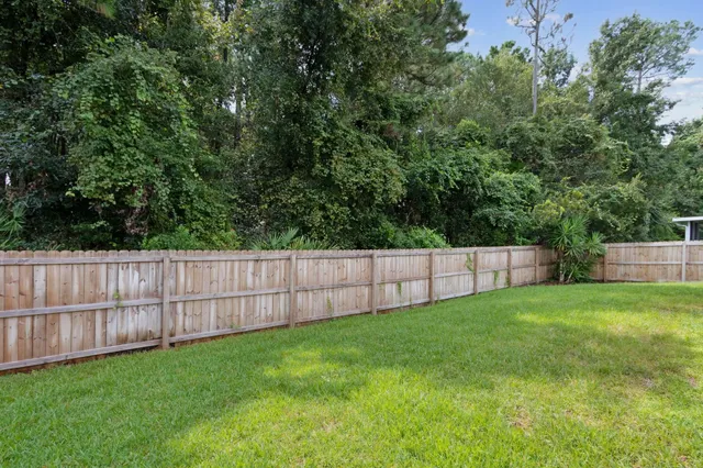 a view of a backyard with a wooden fence
