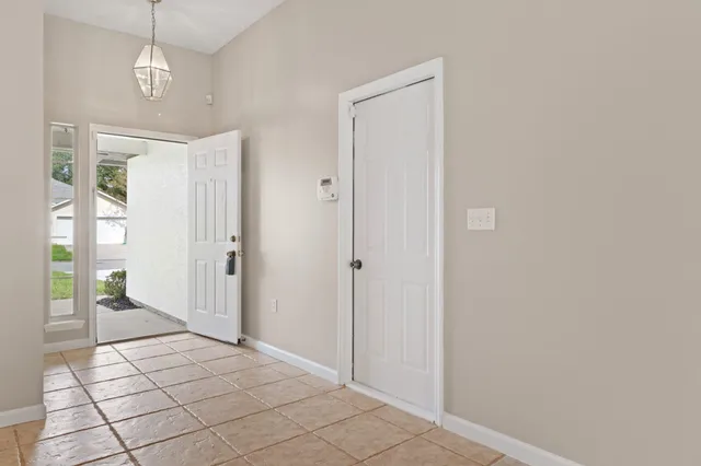 a view of a hallway with wooden floor and a living room