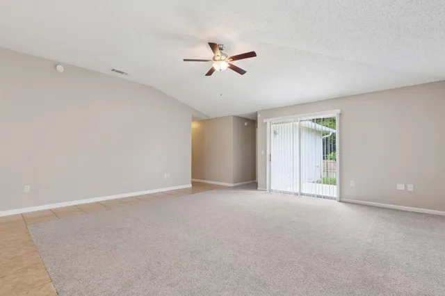 a view of an empty room with a ceiling fan