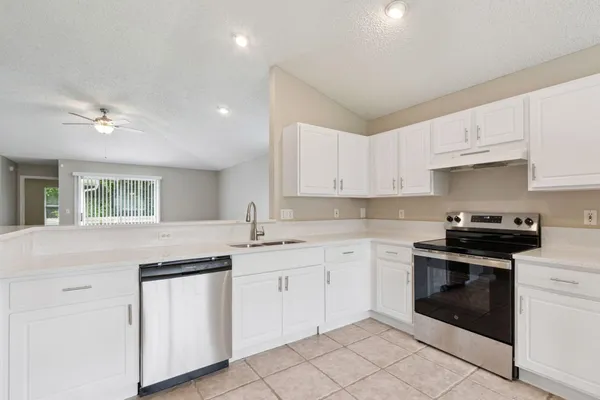 a kitchen with white cabinets stainless steel appliances and sink