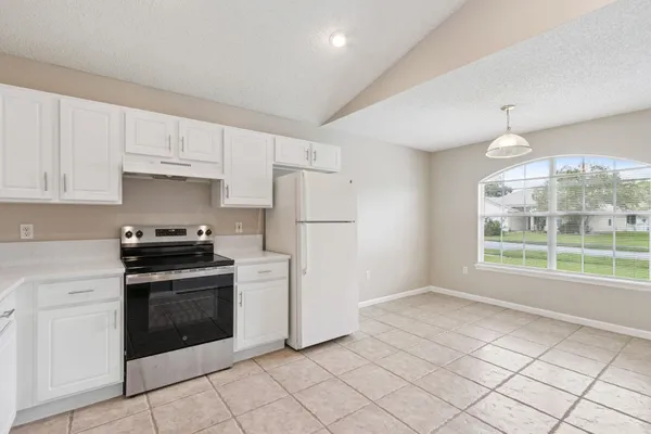 a kitchen with white cabinets and a stove top oven