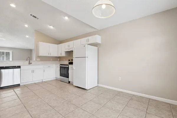 a kitchen with white cabinets and white appliances
