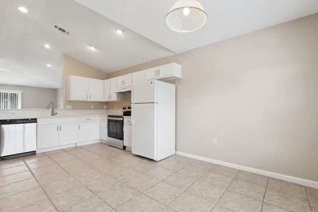 a kitchen with white cabinets and white appliances